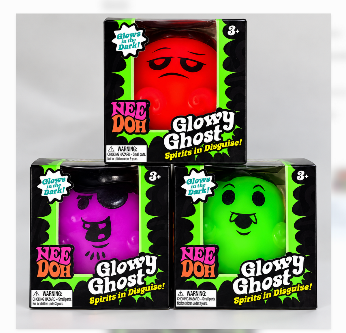 Tres diseños de NeeDoh Glowy Ghost en caja: naranja, morado y verde; se vende uno en color sorpresa